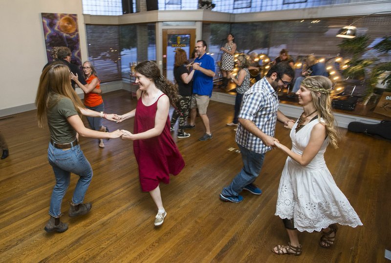 NWA Democrat-Gazette/BEN GOFF @NWABENGOFF Dancers twirl to old-time string music during the Fayetteville Square Dance at the Fayetteville Roots Festival headquarters on the square. The traditional Southern square dances with live bands are held on the last Friday of each month with lessons for newcomers.