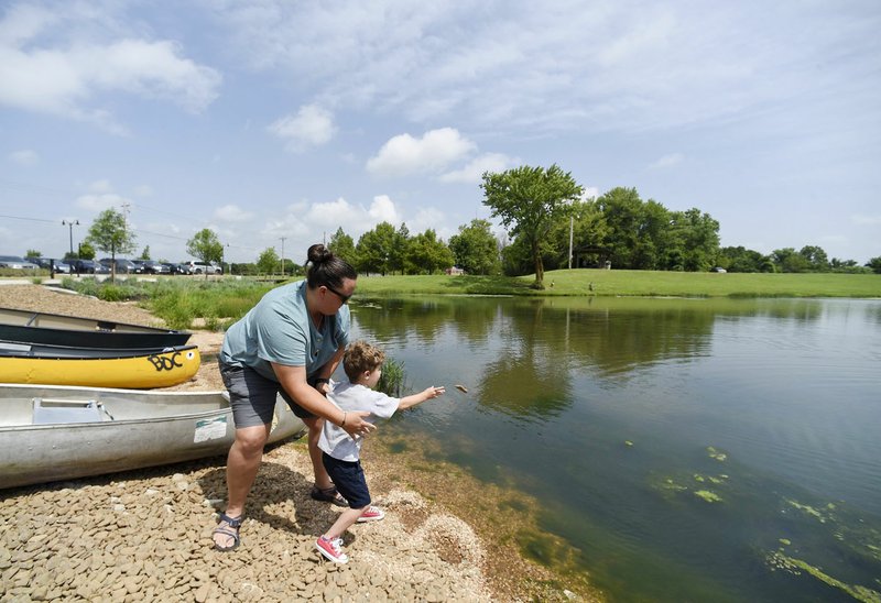 NWA Democrat-Gazette/CHARLIE KAIJO Hannah Cicioni of Rogers and Jude Azzain, 4, of Tulsa, Okla. (from left) skip rocks, Friday, July 5, 2019 at the Thaden field house dock across from Lake Bentonville Park in Bentonville. 

Lake Bentonville Park is undergoing a major renovation and will be closed July 8 through spring 2020