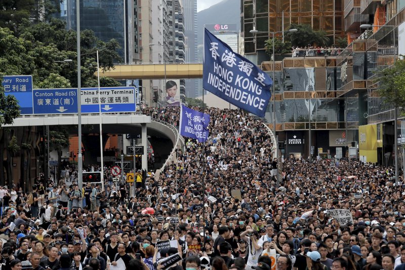 Protesters march with a flag calling for Hong Kong independence in Hong Kong on Sunday, July 7, 2019. Thousands of people, many wearing black shirts and some carrying British flags, were marching in Hong Kong on Sunday, targeting a mainland Chinese audience as a month-old protest movement showed no signs of abating. (AP Photo/Kin Cheung)
