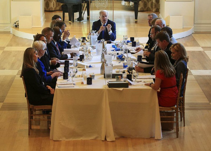 Gov. Asa Hutchinson (center) speaks Monday with the recently appointed secretaries of the state government’s 15 departments during a Cabinet meeting at the Governor’s Mansion in Little Rock. 