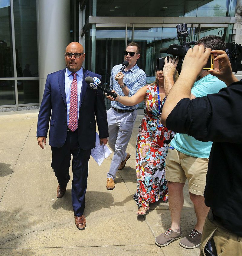 Former state Sen. Jeremy Hutchinson (left) leaves the federal courthouse in Little Rock Tuesday as reporters ask him about pleading guilty to accepting bribes and falsifying tax records. 