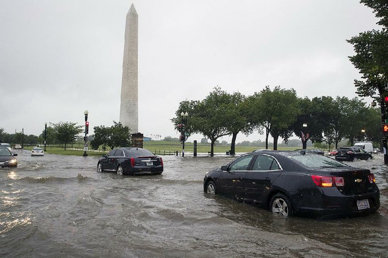 Heavy rainfall Monday flooded the intersection of 15th Street and Constitution Avenue Northwest in Washington, D.C., causing cars to stall near the Washington Monument.