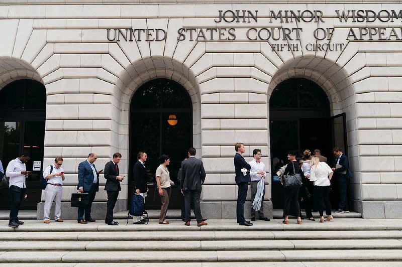 People line up to gain entry to a federal court hearing Tuesday in New Orleans on whether Congress effectively invalidated all of former President Barack Obama’s health care law by negating the tax imposed on people who chose not to buy health insurance. 