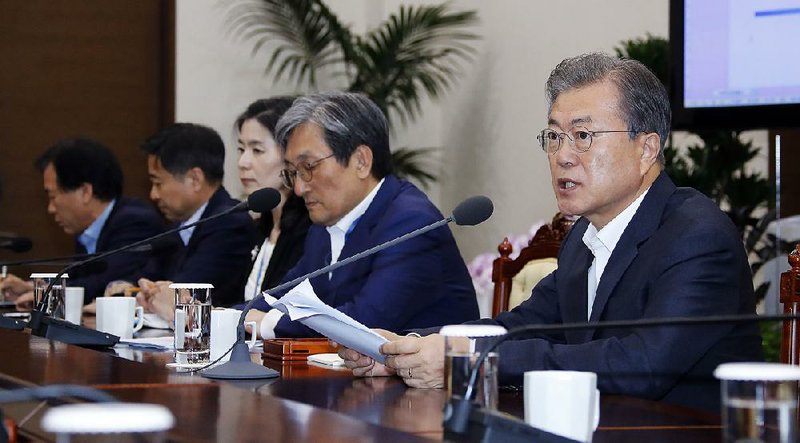 South Korean President Moon Jae-in (right), shown Monday in Seoul, has urged Japan to drop the trade restrictions, which he described as politically motivated. 