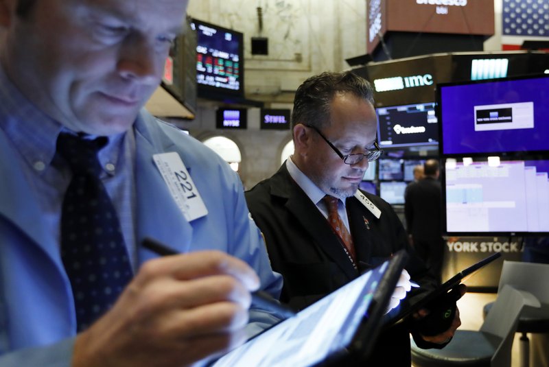 In this May 1, 2019, file photo traders Peter Mancuso, left, and Robert Arciero work on the floor of the New York Stock Exchange.  (AP Photo/Richard Drew, File)