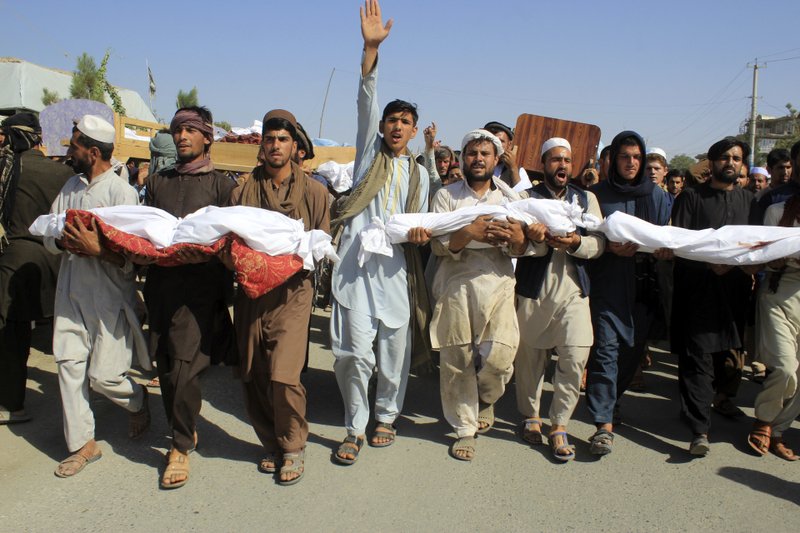 Residents carry bodies killed in an airstrike during a protest in Baghlan province, northern Afghanistan, Tuesday, July 9, 2019. Even as an All-Afghan conference that brought Afghanistan's warring sides together was ending, the airstrike killed seven people, six of them children. (AP Photo/Mehrab Ibrahimi)
