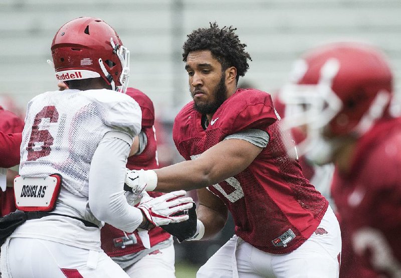 Arkansas offensive lineman Myron Cunningham (right), shown taking part in drills during spring practice in March, was a first-team National Junior College All-American last season while playing left tackle at Iowa Central Community College. 