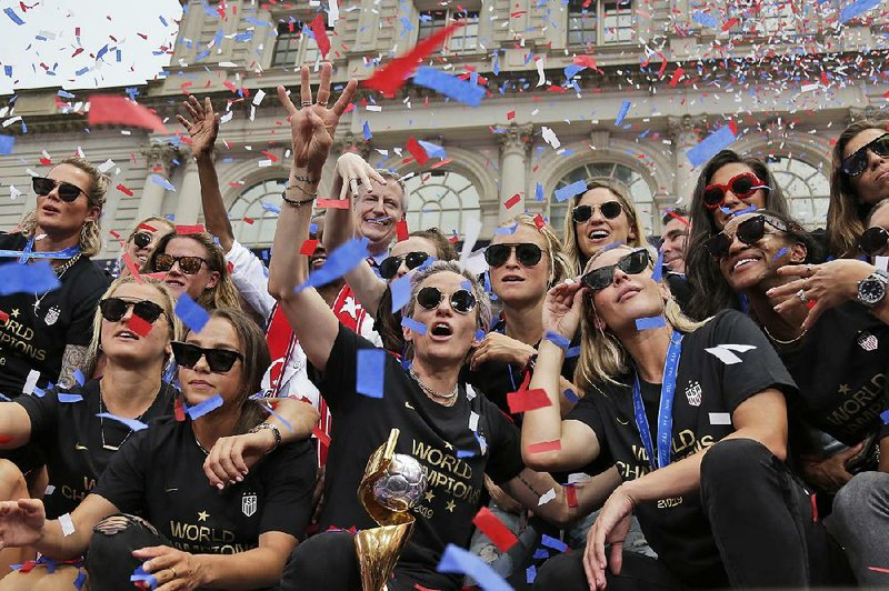 Members of the United States women’s soccer team, which won the World Cup title Sunday, take part in a ticker-tape parade in their honor Wednesday in New York. 