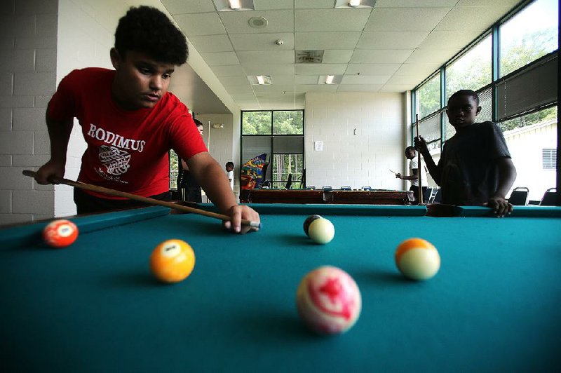 Matthew Angeles, 12, (left) and Jeremiah Jackson, 12, take a break from the heat Wednesday at Little Rock’s Southwest Community Center. City officials have opened the center and three others to residents needing to escape high temperatures after the National Weather Service issued a heat advisory for the area.