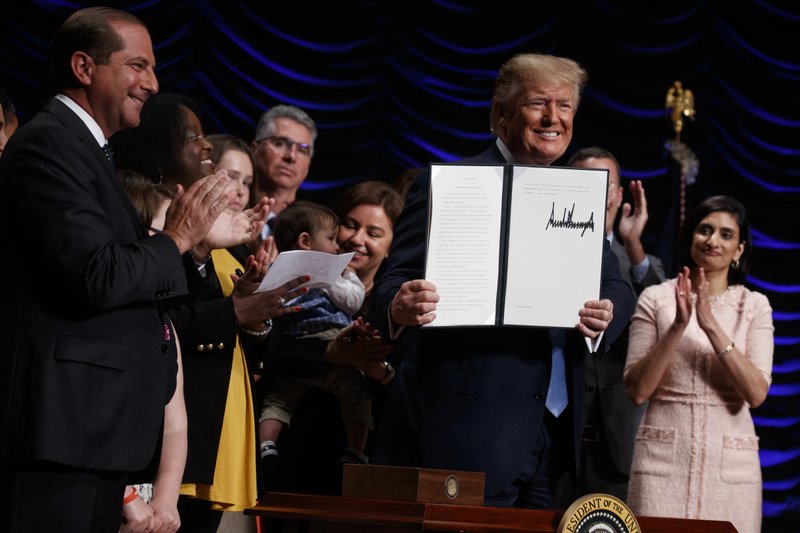 President Donald Trump holds up an executive order on kidney disease care during an event at the Ronald Reagan Building and International Trade Center, Wednesday, July 10, 2019, in Washington. (AP Photo/Evan Vucci)