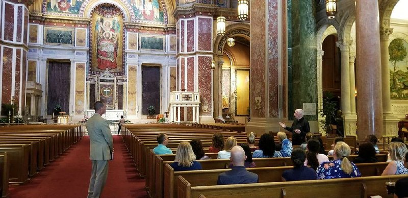 Christopher Murray (left) watches a priest at St. Matthew’s Cathedral in the District speak to Montgomery County teachers about Catholicism.