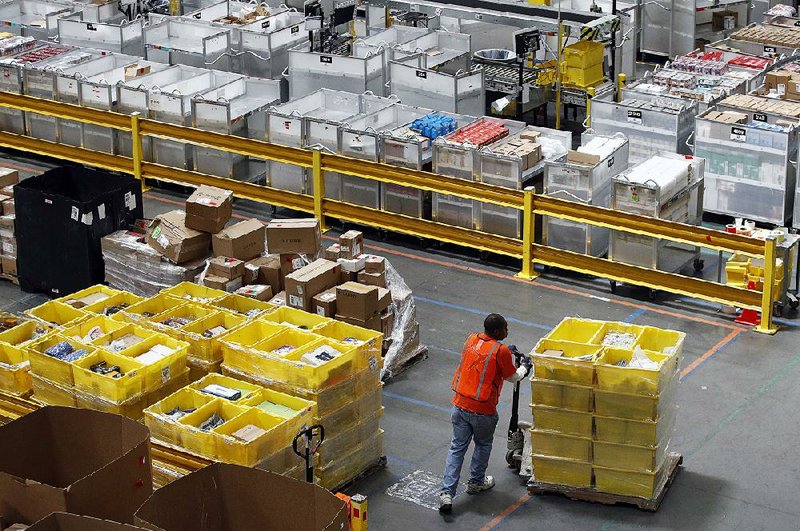 A worker moves pallets of merchandise at an Amazon fulfillment center in Baltimore in 2017. Amazon plans to pay for technological training of about a third of its U.S. workforce. 