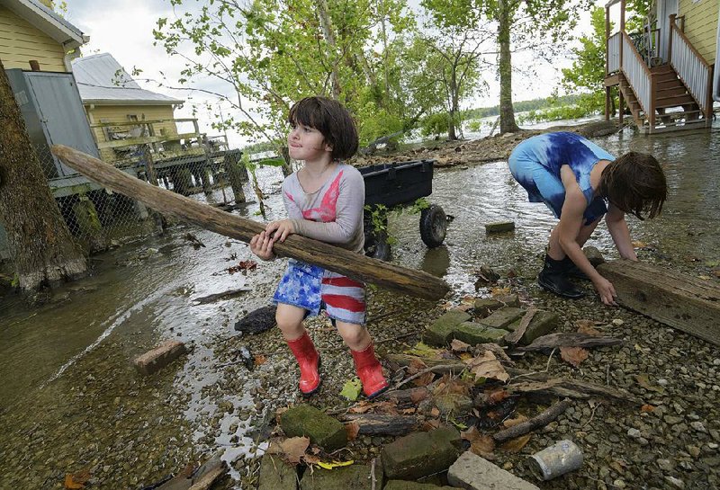 Delilah Campbell, 4, (left) and her sister Tallulah Campbell, 8, clear out driftwood and other debris Thursday near New Orleans as Tropical Storm Barry approaches. 