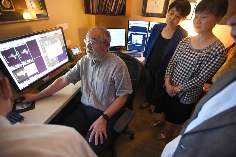 NWA Democrat-Gazette/J.T. WAMPLER Dr. Steven Harms, radiologist at The Breast Center/MANA Clinic in Fayetteville, shows Thursday a group of Chinese doctors and researchers how he reviews images of breast scans.
