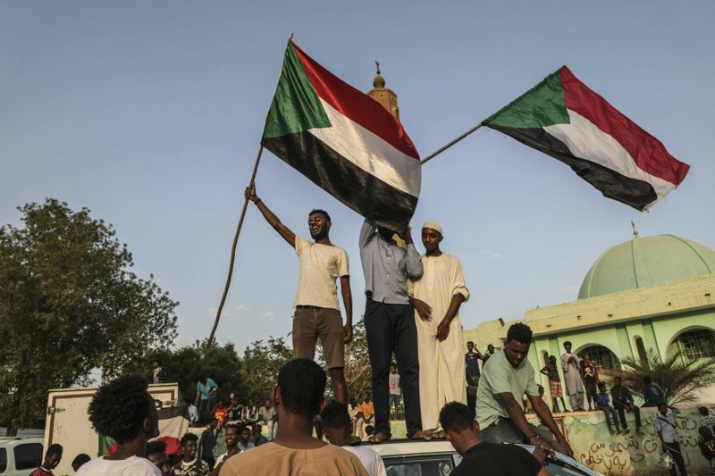 FILE - In this Friday, July 5, 2019, file photo, Sudanese people celebrate in the streets of Khartoum after ruling generals and protest leaders announced they have reached an agreement on the disputed issue of a new governing body. The power-sharing agreement reached between Sudan&#x2019;s military and pro-democracy protesters last week came after the United States and its Arab allies applied intense pressure on both sides amid fears a prolonged crisis could tip the country into civil war, activists and officials said. (AP Photo/File)