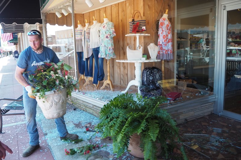 A Magnolia Glass and Mirror employee clears the storefront area of Jennifer's on the Square in Magnolia after a Friday morning accident involving a small SUV plowing into the retail shop's display window. No one was hurt during the incident. 