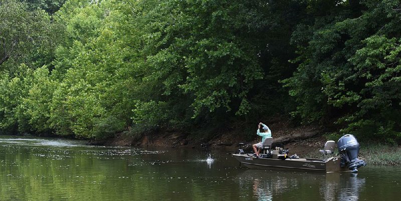 Mike Burnham of Benton fights a Kentucky bass Monday on the Saline River near Benton.