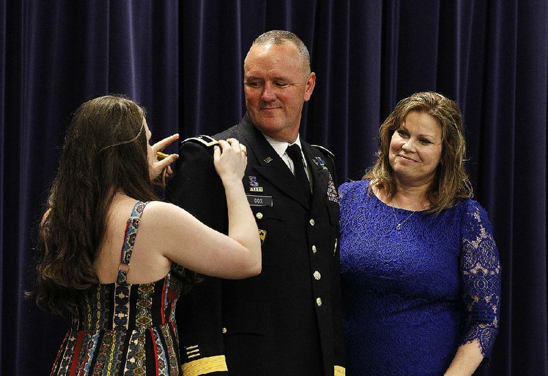 Arkansas National Guard Brig Gen. Bradley Cox’s daughter Jordan (left) and wife, Melissa, (right) put  epaulets signaling his new rank on his uniform Saturday during his promotion ceremony at Camp  Robinson in North Little Rock. More photos are available at www.arkansasonline.com/714promo/ 