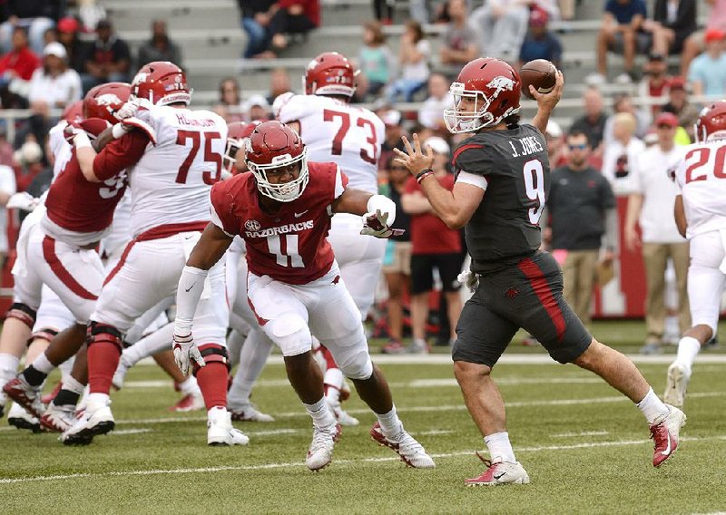 Defensive end Mataio Soli (left) chases John Stephen Jones in the Arkansas Red-White game April 6 at Reynolds Razorback Stadium in Fayetteville. “He’s as good using his hands as I’ve been around,” Arkansas Coach Chad Morris said.