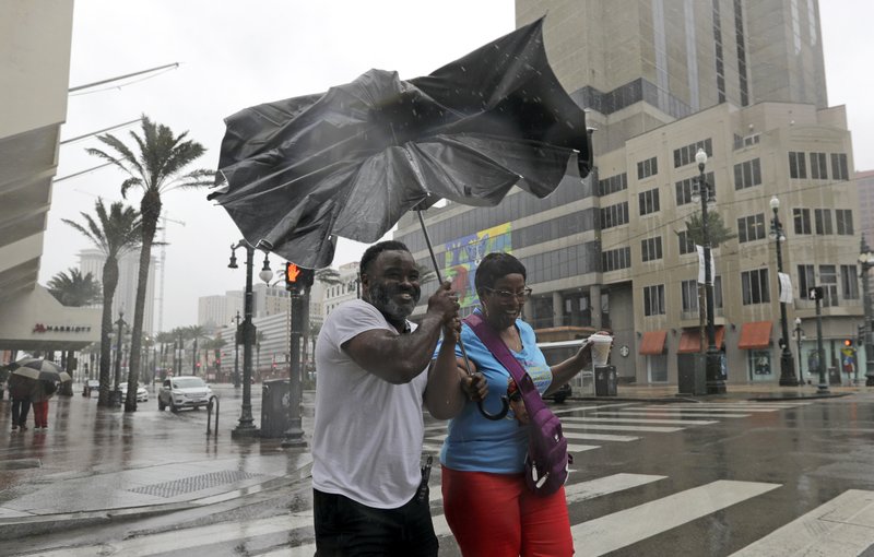 Karon Hill, left, and Celeste Cruz battle the wind and rain from Hurricane Barry as it nears landfall Saturday, July 13, 2019, in New Orleans. (AP Photo/David J. Phillip)