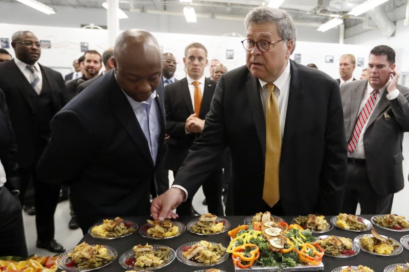 Attorney General William Barr, right, and Sen, Tim Scott, R-S.C., sample food prepared by an inmate culinary arts class during a tour of a federal prison Monday, July 8, 2019, in Edgefield, S.C. (AP Photo/John Bazemore)