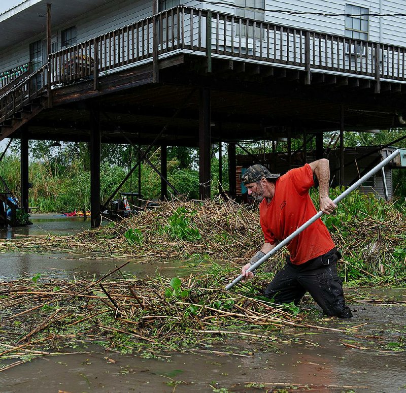 Rowdy Schouest clears debris Sunday in Franklin, La., in the aftermath of the storm. 