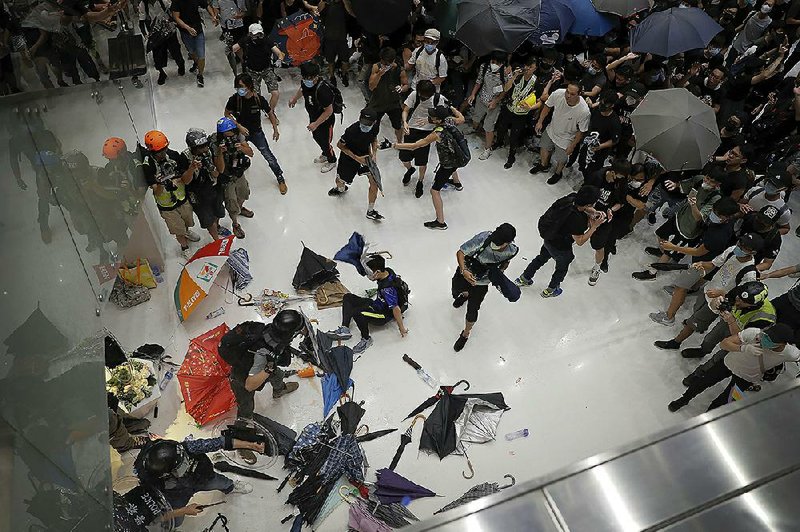 Police officers scuffle with protesters Sunday at a shopping mall in the Sha Tin neighborhood of Hong Kong. 