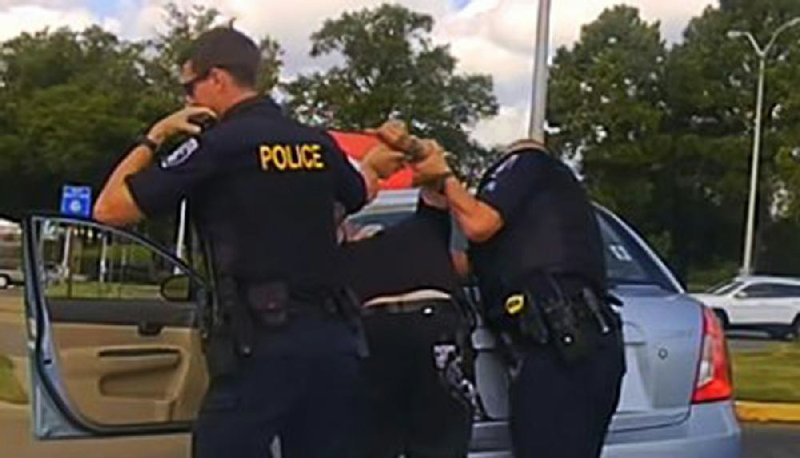 This dash-camera image released by the North Little Rock Police Department shows officer Jon Crowder (right) arresting Kristopher Ryan Lamar in August of last year.