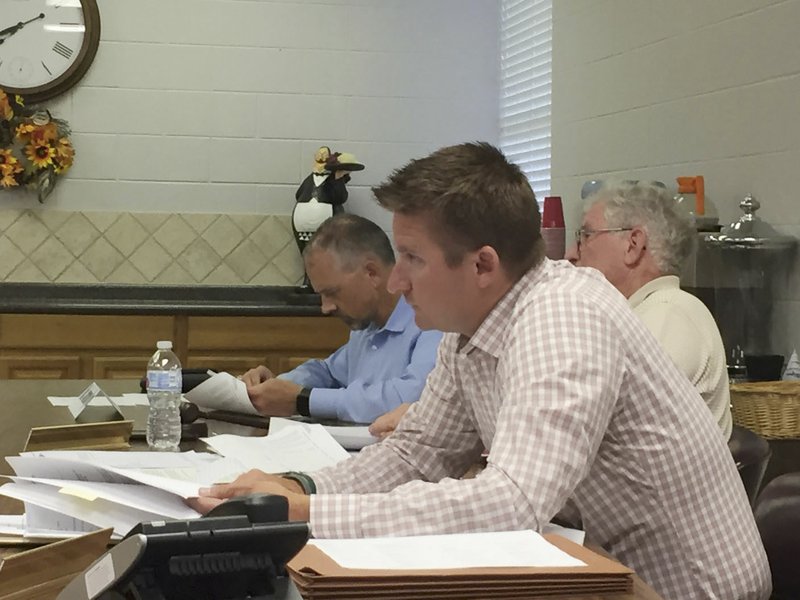 NWA Democrat-Gazette/DAVE PEROZEK Derek Gibson, a Northwest Technical Institute board member, listens Monday during a board meeting in Springdale. Fellow board members Anthony Doss (left) and Tommy Free are seen in the background.