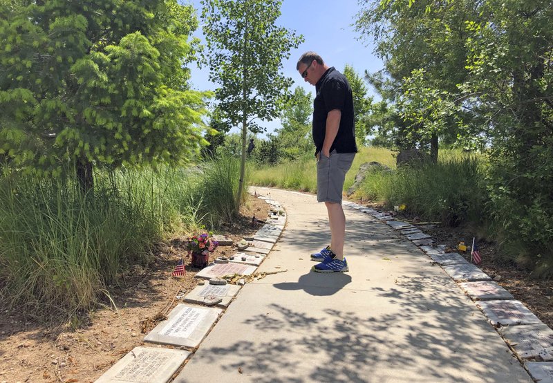 In his June 3, 2019 photo, Bill Arsenault of the Idaho Falls Fire Department looks at memorial stones at the Wildland Firefighters Monument at the National Interagency Fire Center in Boise, Idaho. Federal officials at the NIFC are bolstering mental health resources for wildland firefighters following an apparent increase in suicides. (AP Photo/Keith Ridler)