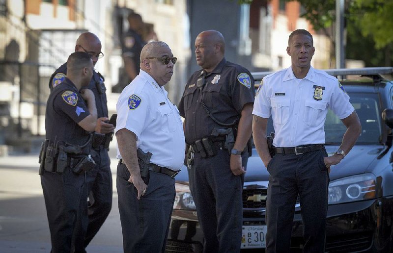 Police Commissioner Michael Harrison (center left) works at the scene of Monday’s shooting in Baltimore. 