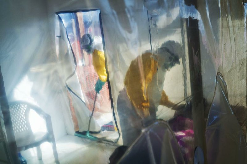 Health workers wear protective suits at an isolation unit in Beni, Congo, as they care for an Ebola patient Saturday. The nation’s Ebola outbreak has killed nearly 1,700 people since August. 