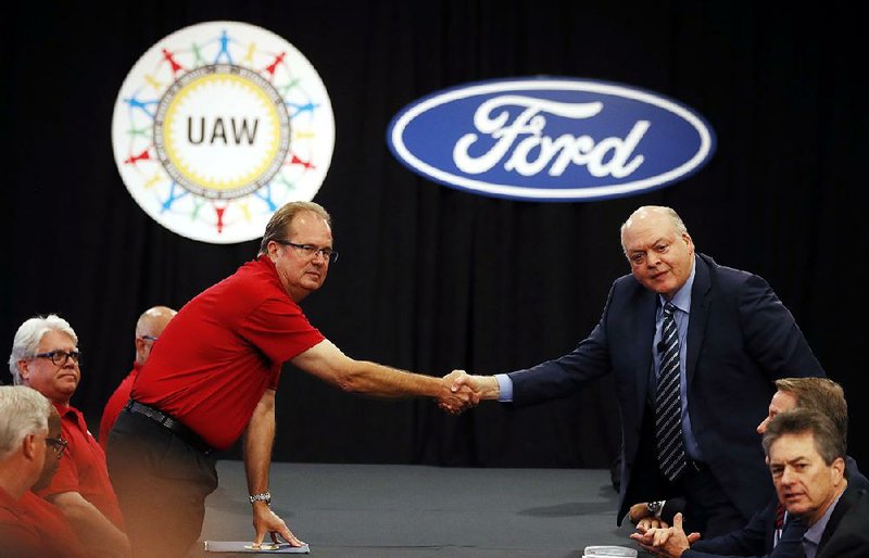 United Auto Workers President Gary Jones (left) and Ford Motor Co. Chief Executive Officer Jim Hackett shake hands to open contract talks Monday in Dearborn, Mich.