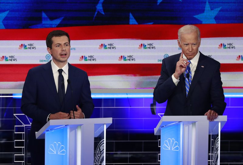 FILE - In this June 27, 2019, file photo, Democratic presidential candidate South Bend Mayor Pete Buttigieg, left, speaks as former vice president Joe Biden gestures during the Democratic primary debate hosted by NBC News at the Adrienne Arsht Center for the Performing Art in Miami. Biden and Buttigieg represent the generational poles of the crowded Democratic presidential primary. Biden is hoping Democratic voters see his decades of experience as the remedy for Trump's presidency. Buttigieg argues that the moment calls for the energy of a new generation. (AP Photo/Wilfredo Lee, File)