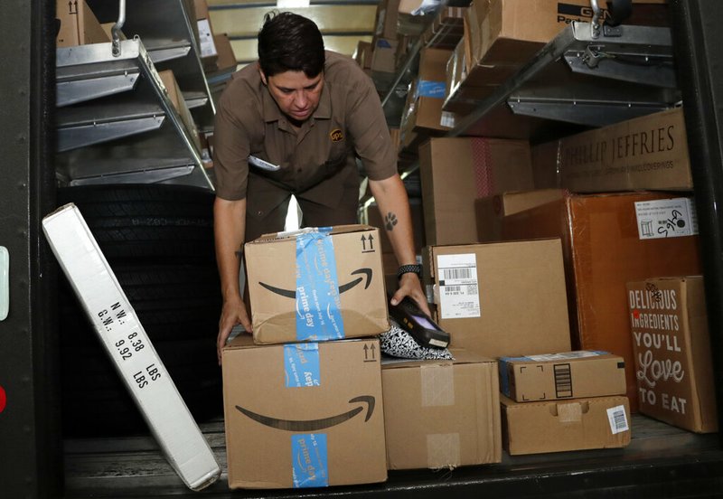 In this July 17, 2018, file photo UPS employee Liz Perez unloads packages for delivery in Miami. On Monday, July 15, 2019, the first day of Amazon Prime Day's 48-hour sales event, large retailers, those that generated annual revenue of at least a billion dollars, enjoyed a 64% increase in online sales compared with an average Monday, according to Adobe Analytics, which measures 80 of the top 100 retailers on the web in the U.S. (AP Photo/Lynne Sladky, File)