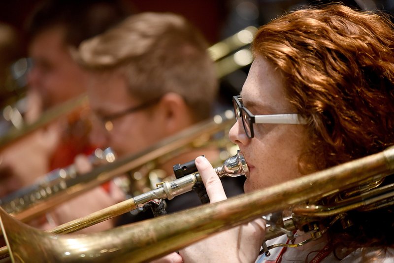 Justin Hobelsberger plays the bass trombone Tuesday with the Honor Jazz Band during practice in the Junior/Senior High Orchestra Summer Music Camp at the University of Arkansas on the Fayetteville campus. The weeklong camp ends with an orchestra concerts at 10 a.m. and band concerts at 1 p.m. Friday at Farmington High School's Performing Arts Center. NWA Democrat-Gazette/DAVID GOTTSCHALK