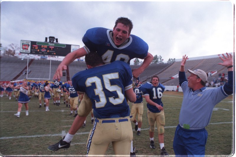 December 4, 1999: Harrison kicker and game MVP Tommy Edwards jumps into the arms of place holder Tyler Lee following Edward's last second field goal to defeat Alma 10-7 in the state 4a football championships Saturday afternoon at War Memorial Stadium.