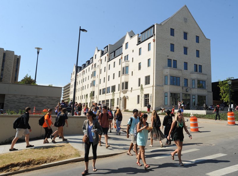 Students cross Dickson Street Tuesday, Sept. 10, 2013, on the University of Arkansas campus in Fayetteville prior to a dedication ceremony for the then newly completed Founders Hall, which provides beds for 214 students and retail and dining space for the University of Arkansas campus community.