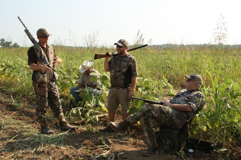 Jeff Lawrence of Little Rock, right, holds court with Tyler Lawrence, middle, John Wilkerson and Adam Ratcliffe (white hat) are shown during the opening day dove hunt at Ratcliffe Farms in Sweet Home.