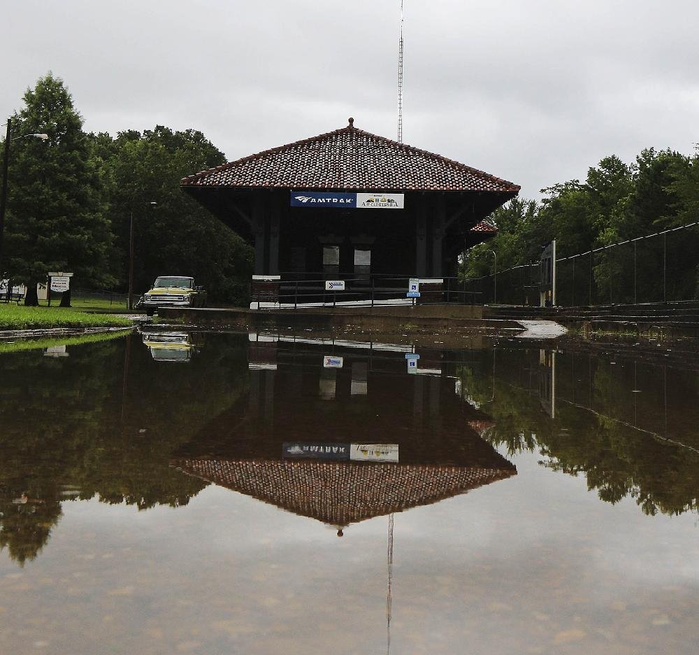 Water covers the road Tuesday in front of the train station in downtown Arkadelphia, where a chaotic scene unfolded as traffic was rerouted from flooded areas, and traffic lights malfunctioned. 