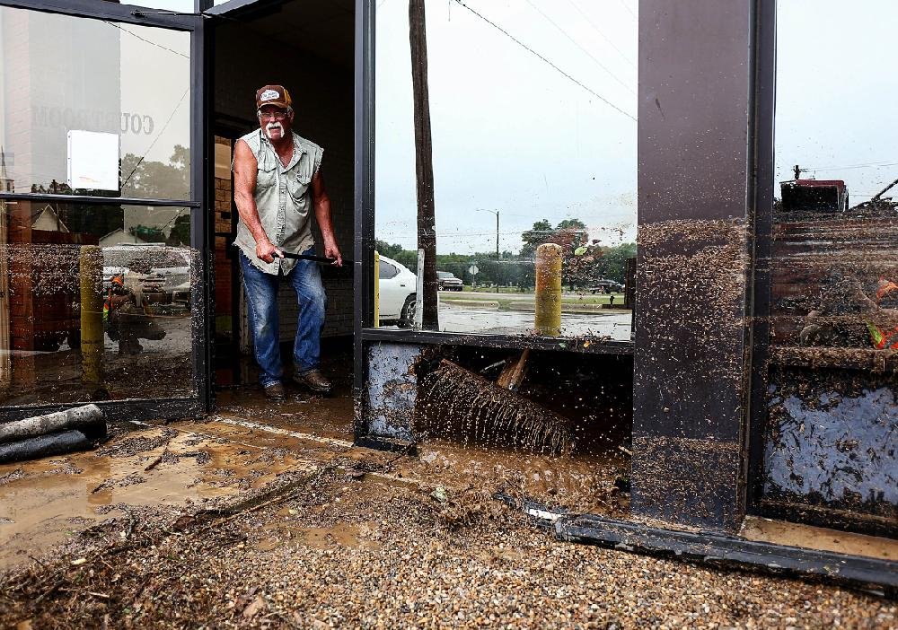Doug Morris hauls a shovel full of debris out of a flooded courtroom Tuesday in Nashville in Howard County. The water caused damage at the county jail and the Police Department. A Tyson Foods plant was evacuated, officials said. 