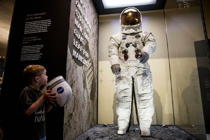 Jack Heely, 5, of Alexandria, Va., views the restored spacesuit worn by Neil Armstrong on the moon after it was unveiled Tuesday at the Smithsonian Air and Space Museum in Washington. 