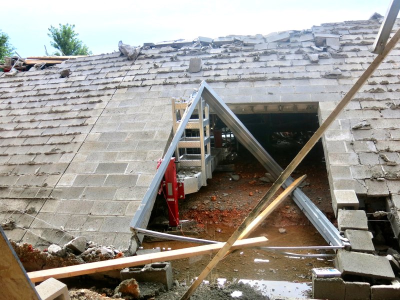 Westside Eagle Observer/SUSAN HOLLAND The east wall of the new high school gymnasium in Gravette, which was under construction, toppled in high winds that accompanied a thunderstorm which popped up in the area on Wednesday afternoon.