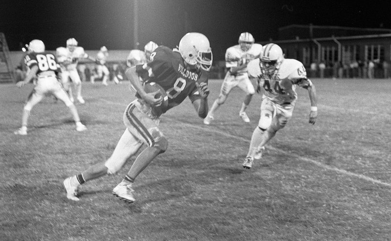 PHOTO COURTESY OF THE SHILOH MUSEUM OF THE OZARKS Chris Smith (8) of Springdale heads for the end zone in a game against Rogers in 1986. Smith was a multi-sport standout at Springdale and is a member of the Springdale Hall of Fame.