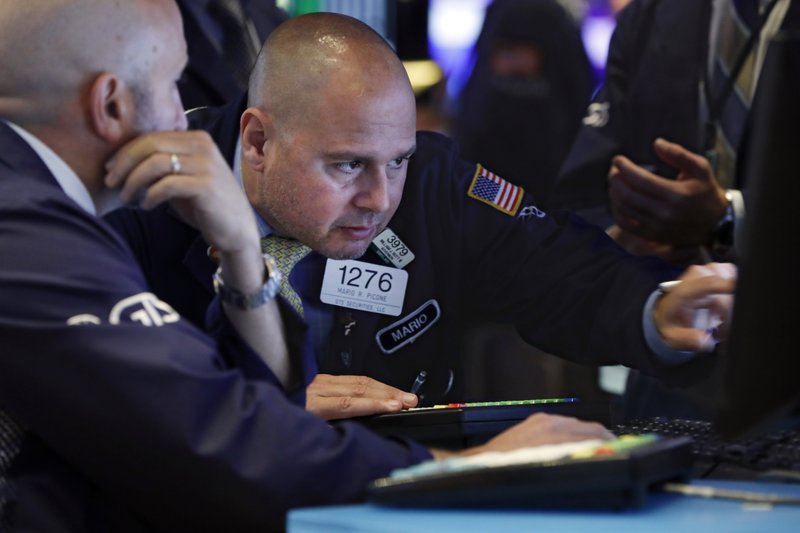 In this June 18, 2019, file photo specialist Mario Picone, right, works on the floor of the New York Stock Exchange.  (AP Photo/Richard Drew, File)