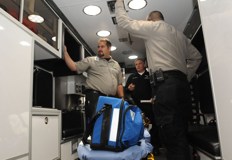 Jeremy Goodwin (left) with Mercy of Northwest Arkansas shows Tuesday Jan. 5, 2016 equipment inside a new ambulance stationed at the Hickory Creek fire station on Arkansas 264 near Beaver Lake.