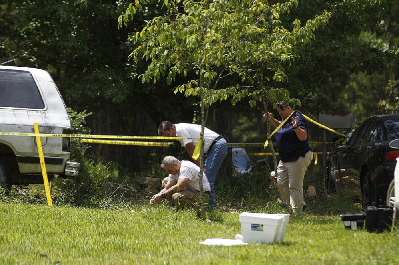 Stone County sheriff’s deputies and Arkansas State Police investigators gather evidence Thursday in a rural area of the county where Sgt. Mike Stephen of the Stone County sheriff’s office was killed after responding to a call. More photos are available at arkansasonline.com/719shooting/ 
