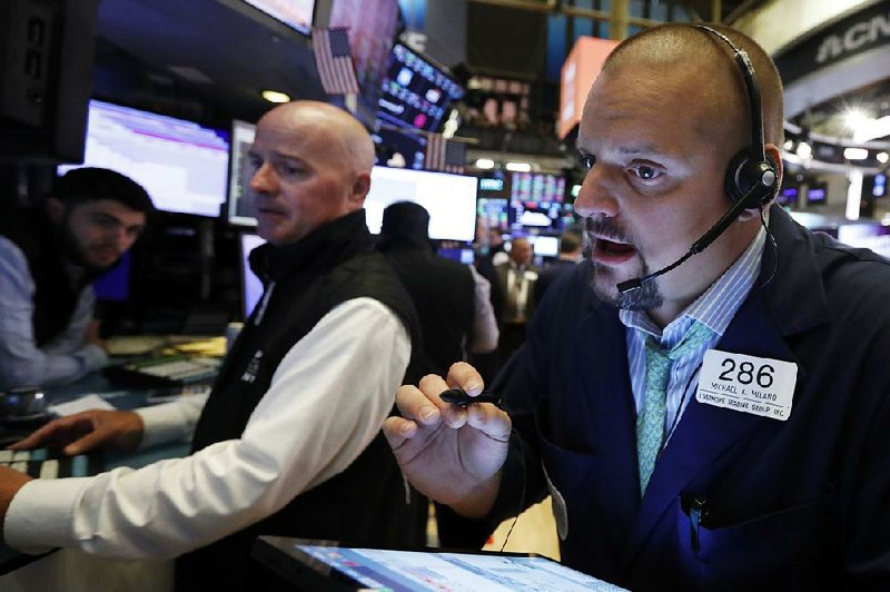 Trader Michael Milano (right) works on the floor of the New York Stock Exchange on Thursday as U.S. stocks moved lower in early trading before rallying in the afternoon to close in positive territory. 