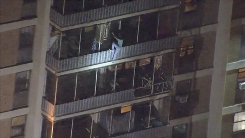 This image taken from video provided by WPVI-TV shows a man scaling down the side of a 19-story high-rise building in Philadelphia to escape a fire, Thursday, July 18, 2019. The fire at the Holden Tower started around 9:30 p.m. Thursday. It apparently started in a trash chute, causing flames to shoot out and spread heavy smoke to all floors of the building. (WPVI-TV via AP) MANDATORY CREDIT

