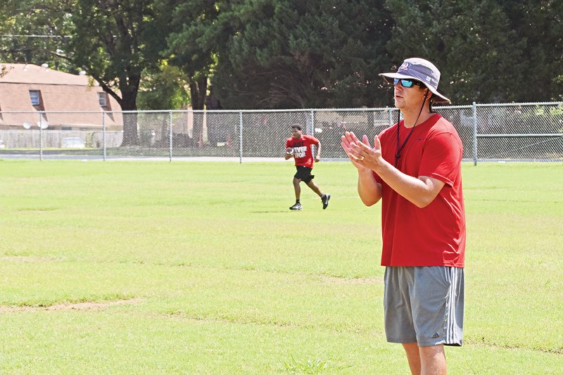 Jacksonville Titans interim head football coach Jordan Johnston watches his players near the end of drills Wednesday morning. Johnston was named interim coach after Barry Hickingbotham resigned to become transportation director for the Jacksonville North Pulaski School District.